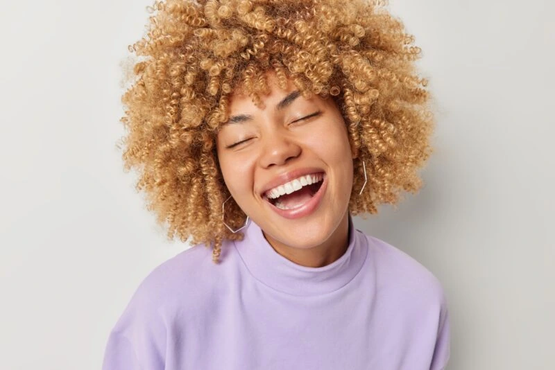 Portrait,Of,Happy,Positive,Woman,Keeps,Eyes,Closed,Smiles,Broadly Cosmetic Dentist in Paso Robles